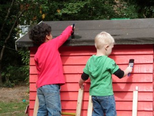 Children painting the wooden house circa 2010s